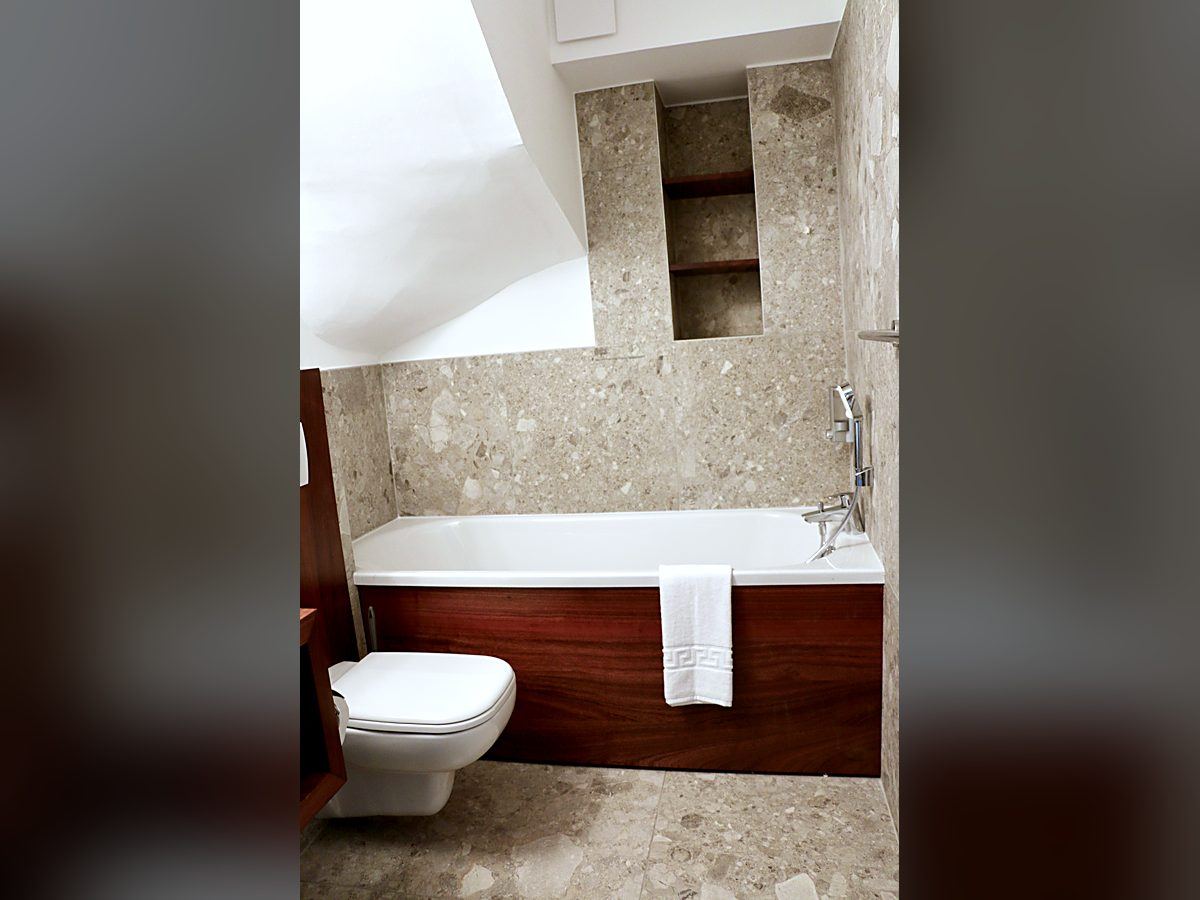 Salle de bains sous pente avec baignoire, niche et WC suspendu, Tropic Appart'Hôtel